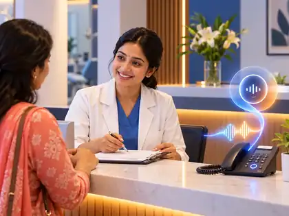 Clinic receptionist smiling at a patient while a glowing voice icon sits on the desk phone